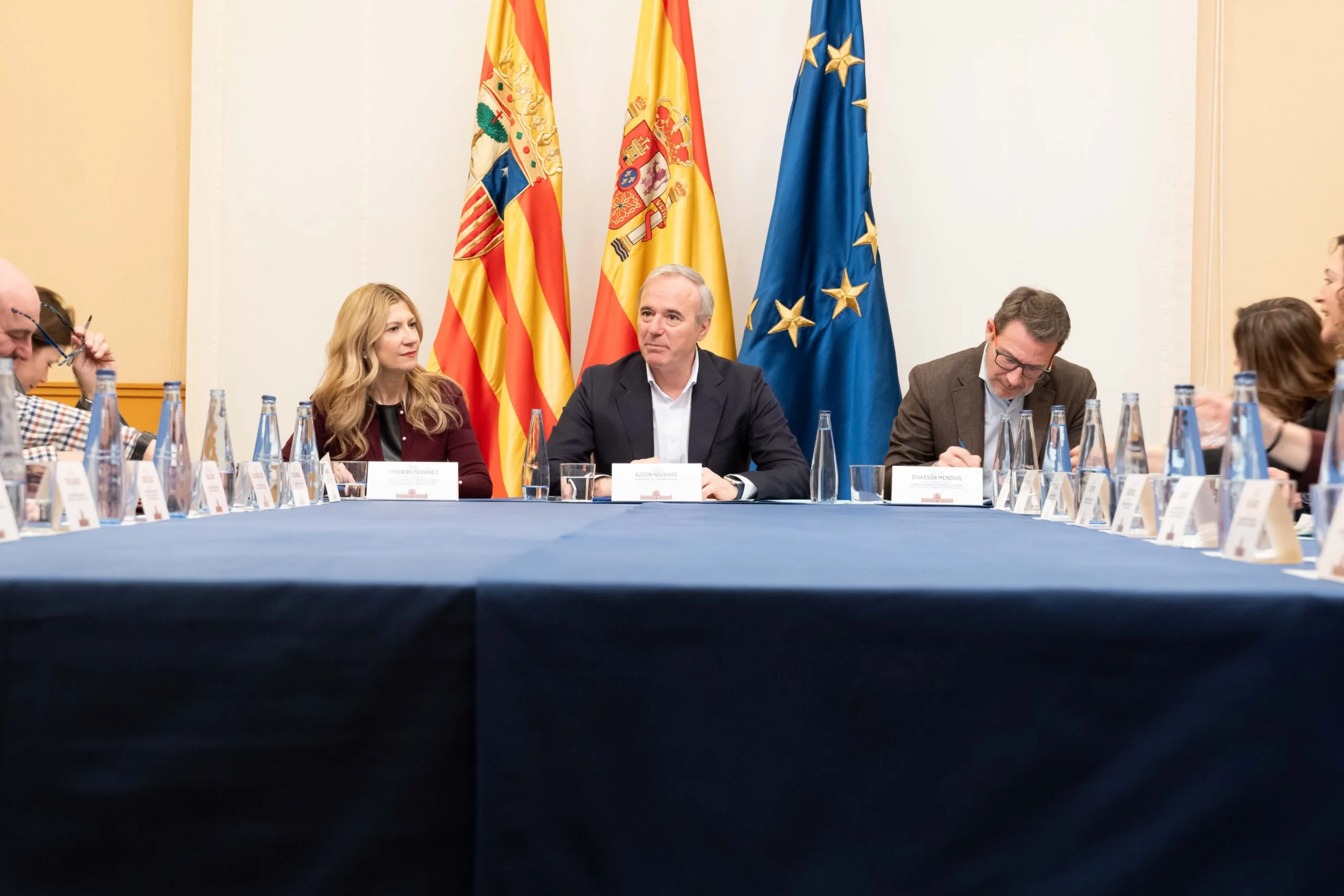 Reunión institucional sobre la cuota cero para autónomos en Aragón Reunión institucional en Aragón sobre la implantación de la cuota cero para autónomos, con representantes del Gobierno y banderas oficiales al fondo.