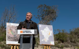 El presidente de Aragón interviene en Perdiguera durante la presentación del plan de reforestación acompañado de mapas de zonas de actuación.