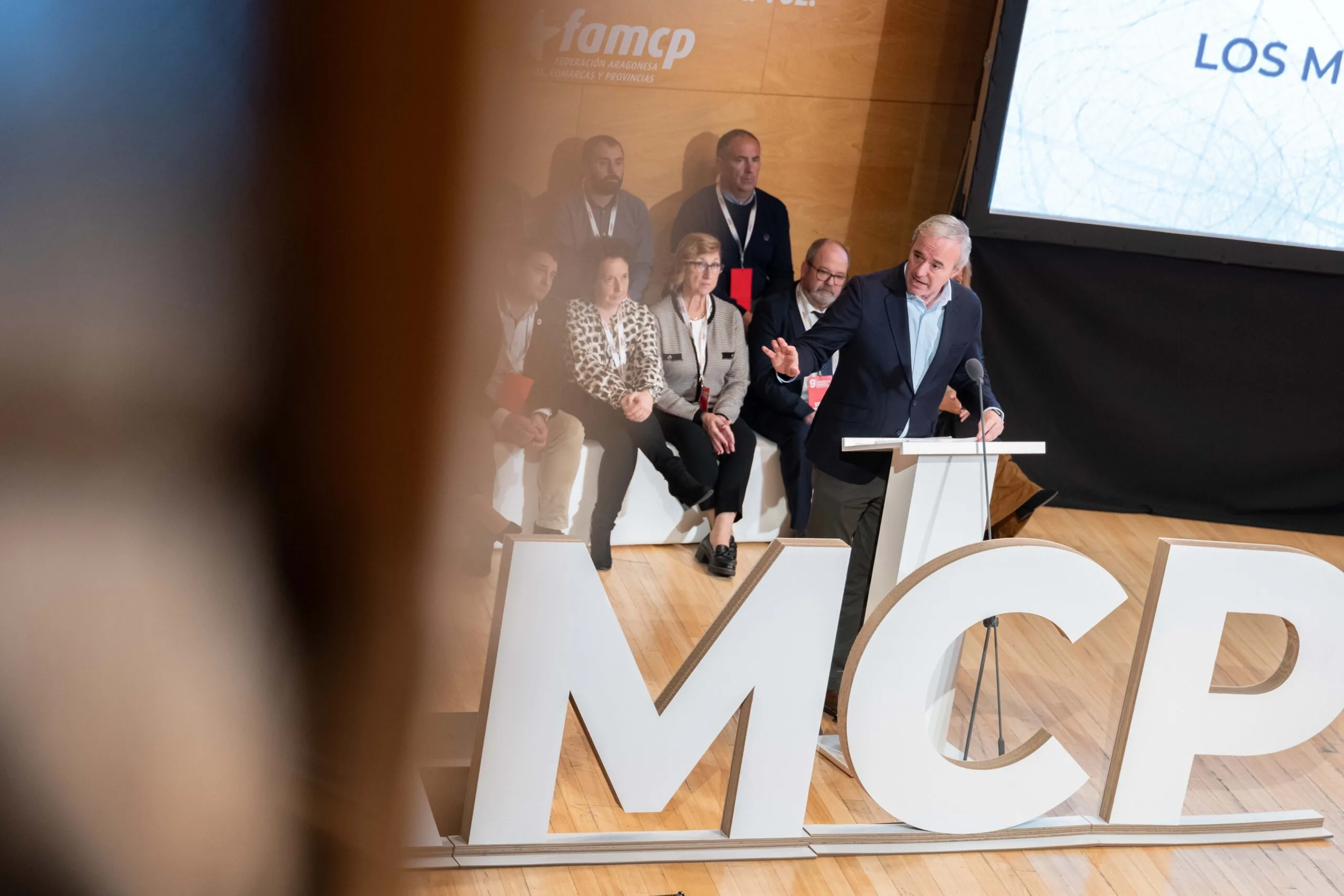 Intervención del presidente de Aragón sobre financiación local El presidente de Aragón interviene en un acto sobre financiación local ante representantes municipales en un auditorio.