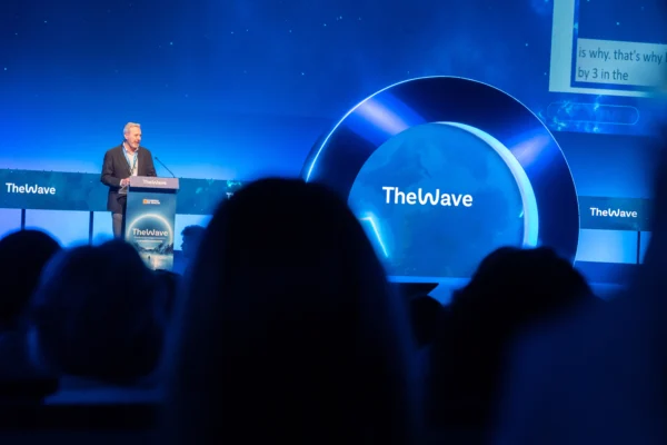 Ponencia en el congreso tecnológico The Wave, con escenario iluminado y público asistente
